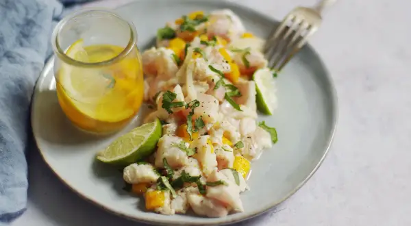 Délicieux ceviche de lieu noir frais, garni de mangue, coriandre et citron vert, servi avec une vinaigrette citronnée.