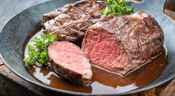 Filet mignon de chevreuil aux champignons, tendre et juteux, servi dans sa sauce avec du thym frais. Une recette savoureuse.