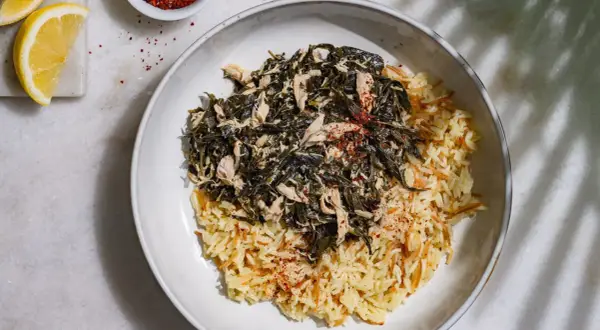 Un plat de mloukhia libanais avec du riz aux vermicelles, garni de poulet effiloché et d'épices rouges.