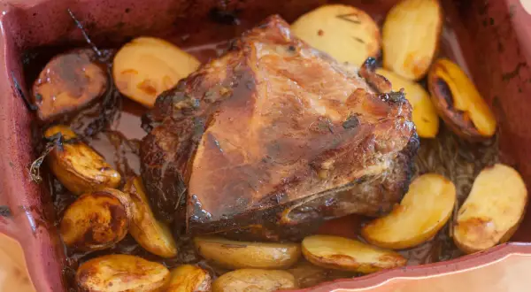 Palette de porc au four, dorée et juteuse, accompagnée de pommes de terre rôties. Une recette simple et savoureuse.