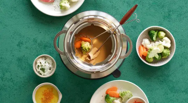 Fondue au bouillon cube avec viande, brocolis, chou-fleur et carottes. Des sauces accompagnent ce plat convivial.