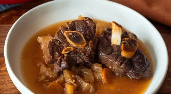 Un plat réconfortant de jarret de cerf mijoté avec des carottes et des pommes de terre dans un bouillon savoureux.