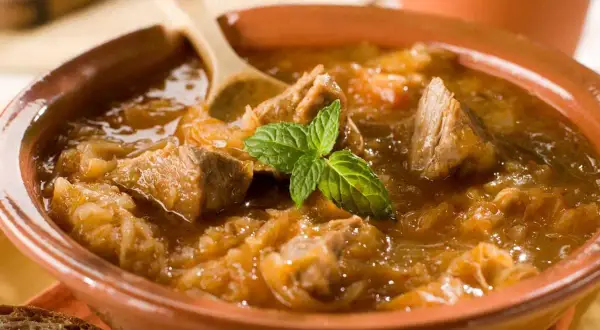 Un plat de goulash polonais réconfortant, avec des morceaux de viande tendre et du chou, garni de menthe fraîche. Parfait pour une recette maison.