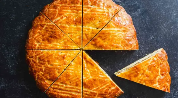 Un délicieux gâteau arménien, doré et coupé en parts, avec une tranche déjà servie.