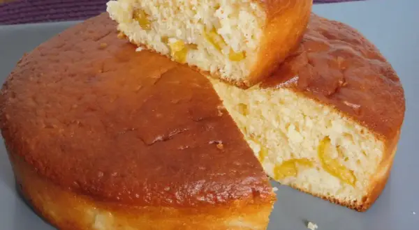 Un gâteau vosgien aux mirabelles, doré et moelleux, avec des morceaux de fruits jaunes visibles à l'intérieur.