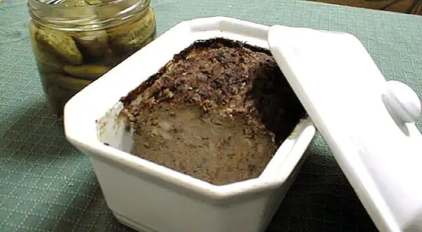 Terrine de foie de volaille à l'ancienne, prête à être dégustée avec des cornichons croquants.