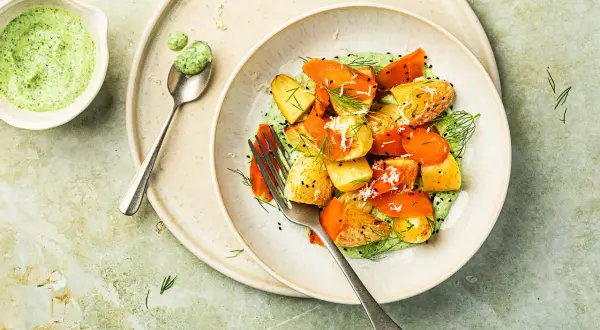 Délicieuse recette pomme de terre carotte en sauce verte crémeuse, garnie d'herbes fraîches et de graines de sésame noir.