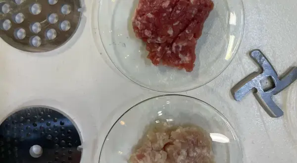Préparation de viande hachée pour savoir combien de sel et poivre par kg de viande. Disques de hachoir et lames à proximité.