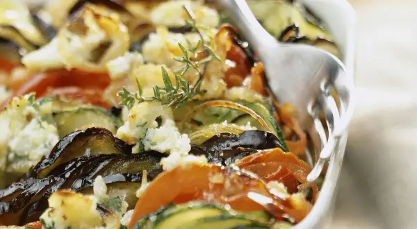 Gratin de légumes aux herbes, une recette ricotta savoureuse. Courgettes, aubergines et tomates cuites au four avec une touche de fromage frais.