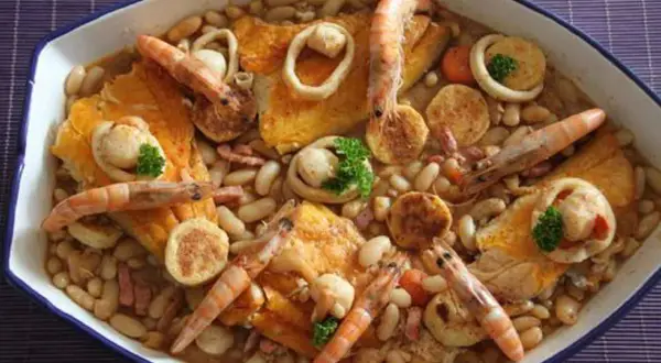 Un cassoulet de la mer facile, un plat généreux avec des crevettes, des calamars et des poissons sur un lit de haricots blancs.