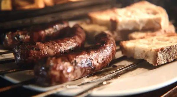 Figatelli grillés au four, accompagnés de tranches de pain rustique. Une recette simple et savoureuse.