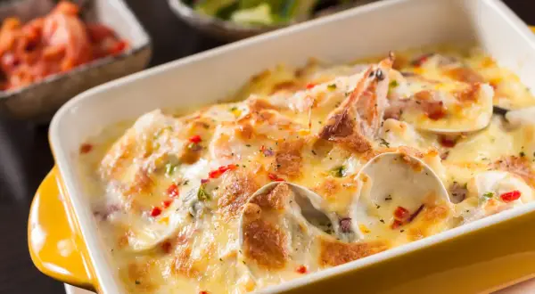 Gratin de coquilles Saint-Jacques, moules, crevettes et champignons, nappé d'une sauce crémeuse et gratiné au fromage. Un délice !