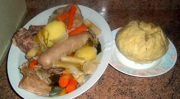 Un plat généreux de la mique origine, avec saucisse, légumes et viande, accompagné d'une mique ronde.