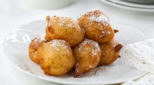 Délicieuses beignets saupoudrés de sucre glace, parfaits pour une recette crotte d'âne maison.
