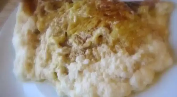 Une omelette normande dorée, moelleuse et savoureuse, servie sur une assiette blanche.