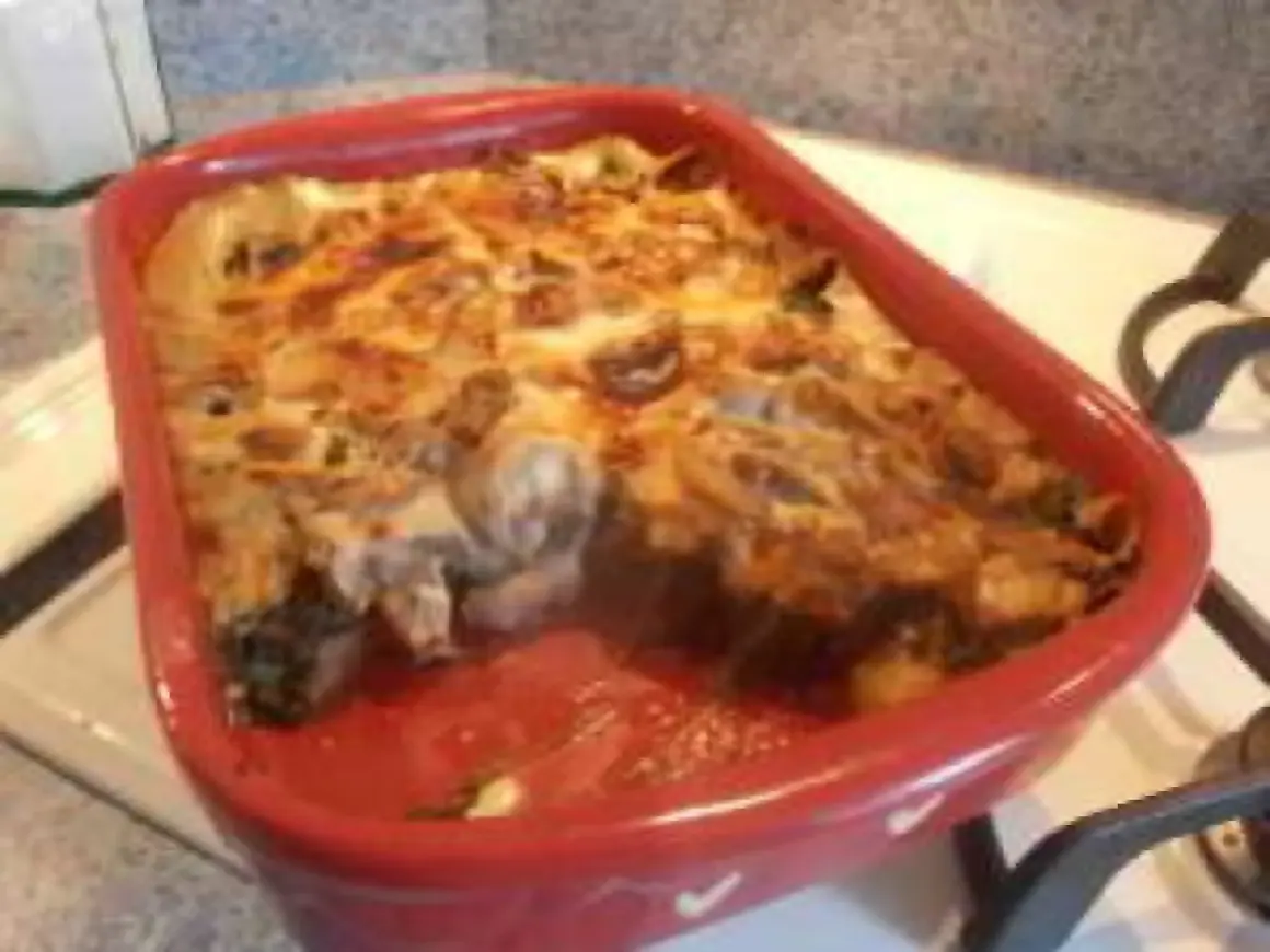 Un gratin des Chartreux tout juste sorti du four, fumant et doré, dans un plat rouge.