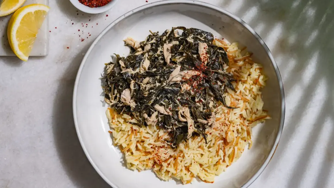 Un plat de mloukhia libanais avec du riz aux vermicelles, garni de poulet effiloché et d'épices rouges.