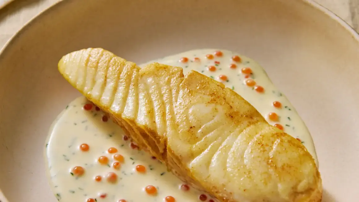 Un flétan poêlé, nappé d'une sauce crémeuse aux œufs de poisson, une flétan recette gastronomique d'exception.