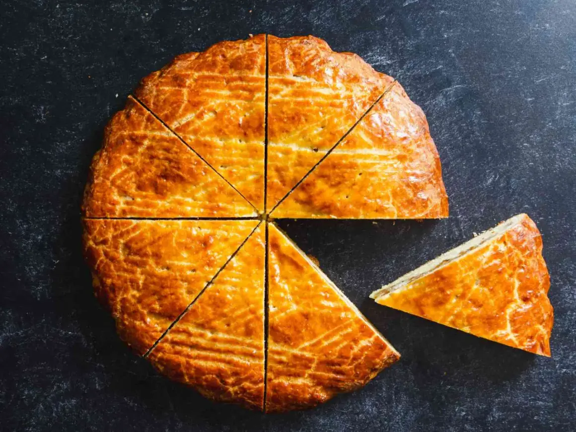 Un délicieux gâteau arménien, doré et coupé en parts, avec une tranche déjà servie.