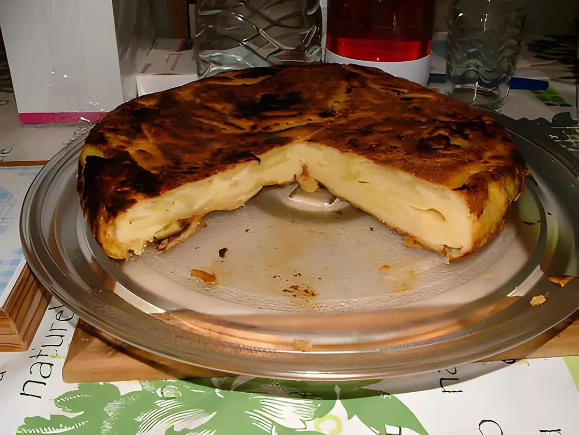 Une délicieuse farinette aux pommes, dorée et moelleuse, servie sur un plat en verre. Un vrai régal !