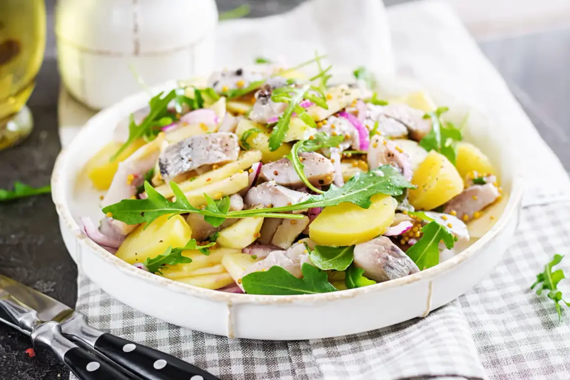 Salade de pommes de terre et hareng frais à la poêle, garnie de roquette et d'oignons rouges. Une recette simple et savoureuse.