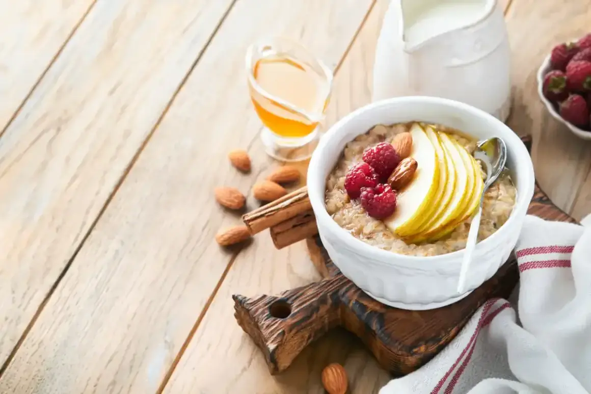 Délicieuse bouillie bretonne garnie de fruits rouges, poire et amandes, avec du miel et du lait à côté.