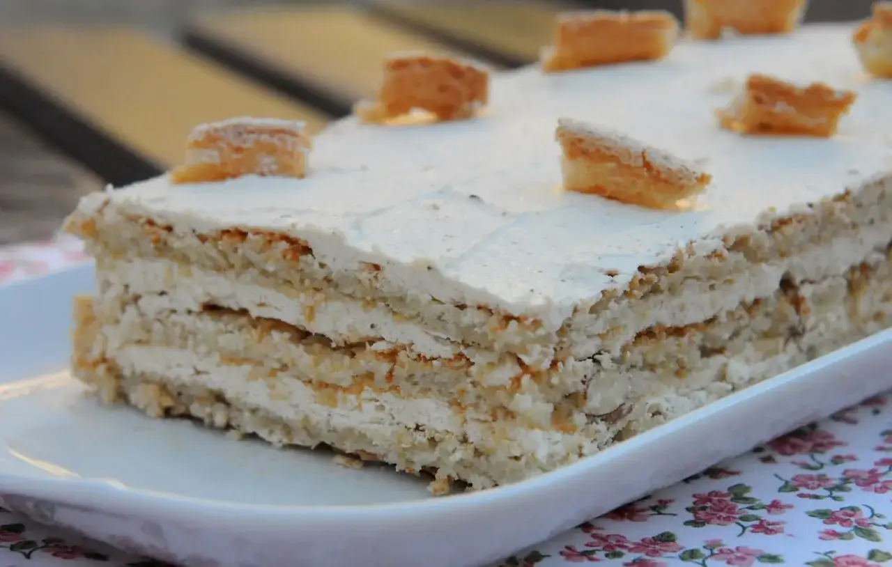 Gâteau Castel, un délice aux couches de biscuit et crème, orné de petits morceaux croustillants. Son origine est un mystère gourmand.