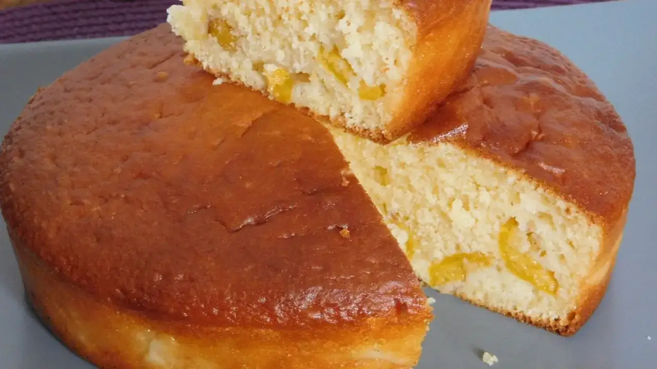 Un gâteau vosgien aux mirabelles, doré et moelleux, avec des morceaux de fruits jaunes visibles à l'intérieur.