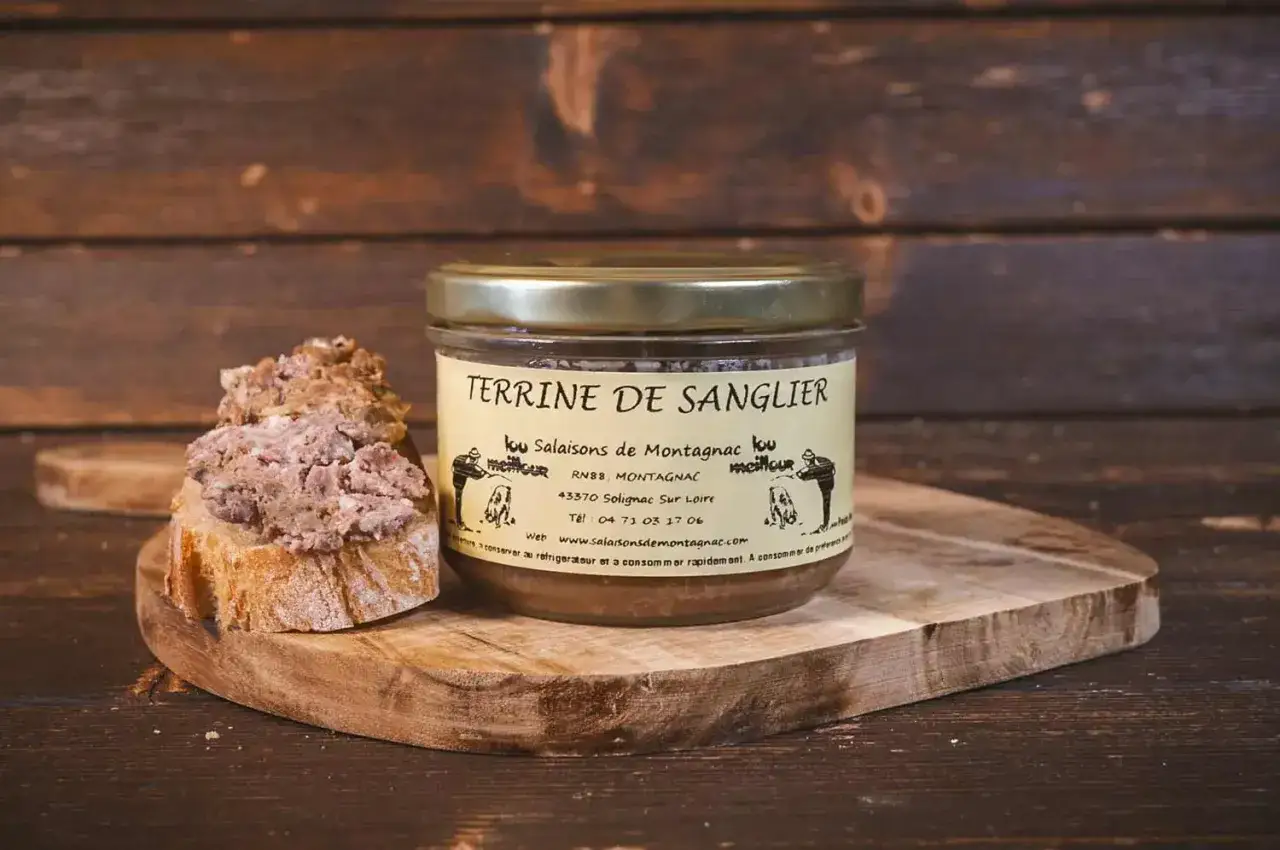 Un bocal de terrine de sanglier stérilisée, prêt à être dégusté sur des toasts de pain croustillant.