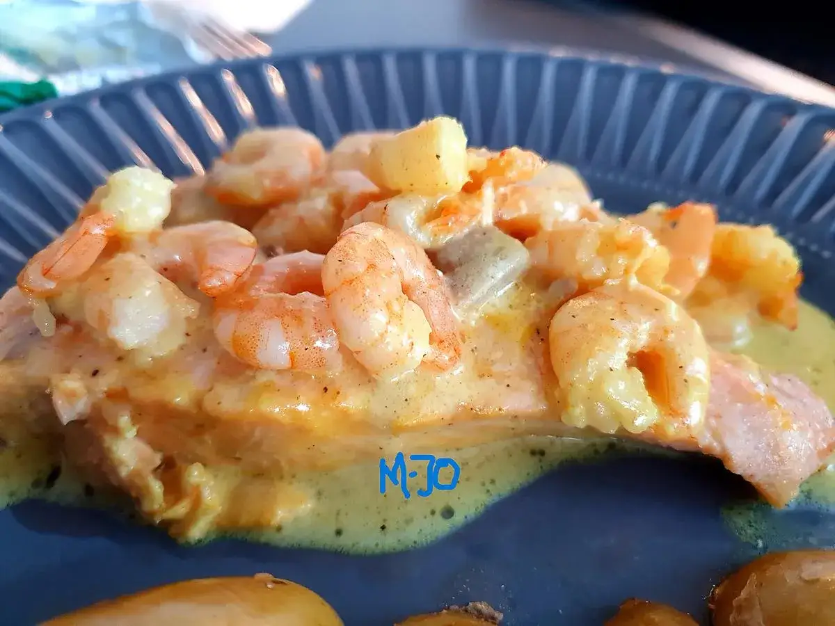 Un délicieux saumon sauce crevette, nappé d'une sauce crémeuse et garni de crevettes roses. Un plat savoureux et coloré.