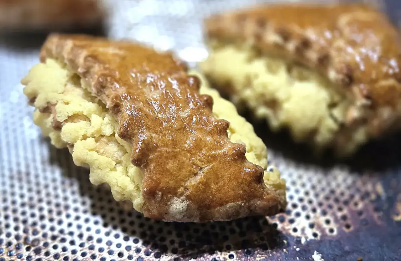 Gâteau arménien, deux biscuits dorés et croustillants, fourrés d'une pâte légère et friable, prêts à être dégustés.