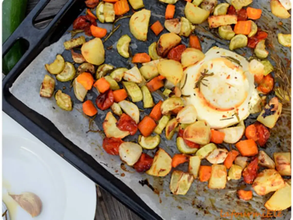 Légumes rôtis sur une plaque de cuisson avec une boule de ricotta au centre. Une idée de recette ricotta simple et savoureuse.