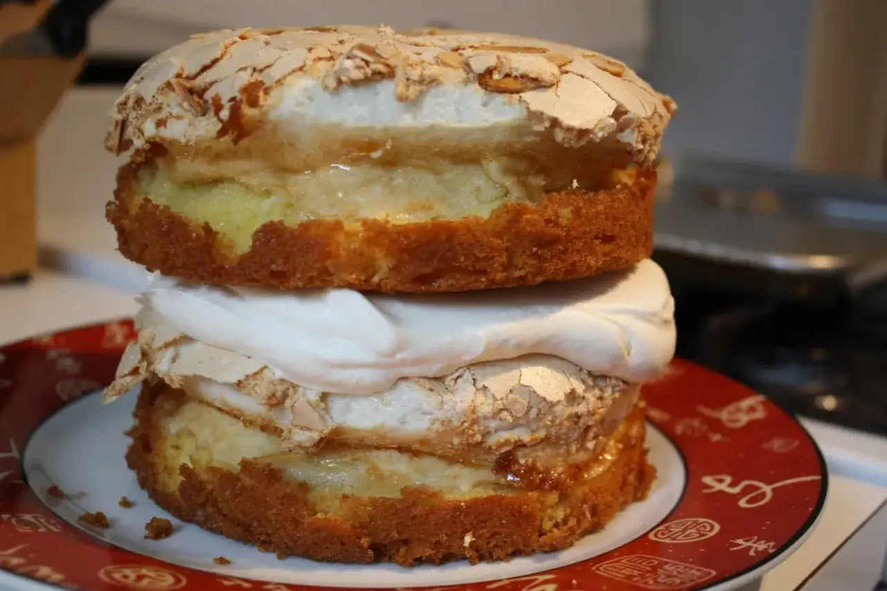 Un délicieux gâteau maréchal, empilé de couches de génoise, de crème et de meringue craquante, prêt à être dégusté.