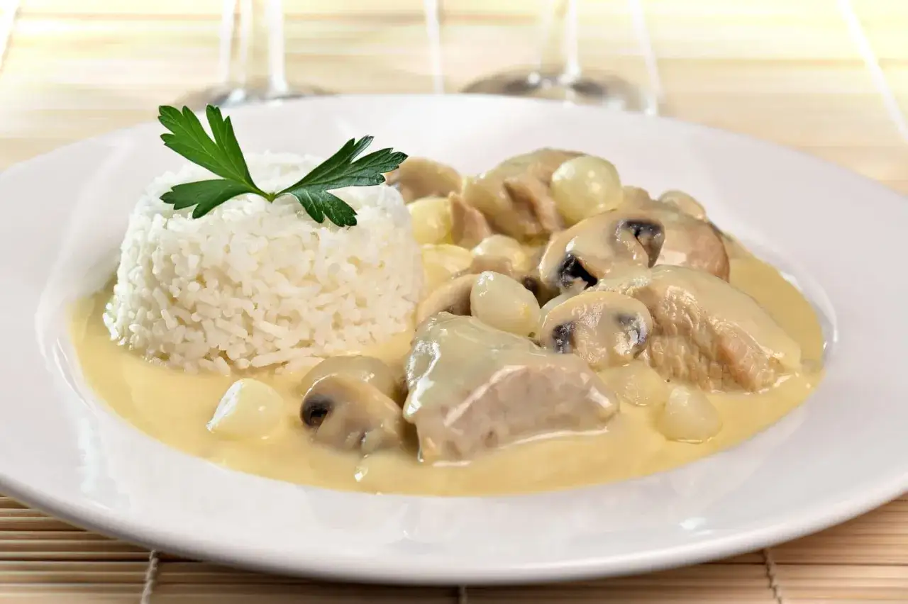 Délicieuse recette de fraise de veau en blanquette, servie avec du riz blanc et garnie de persil frais. Un plat réconfortant et savoureux.