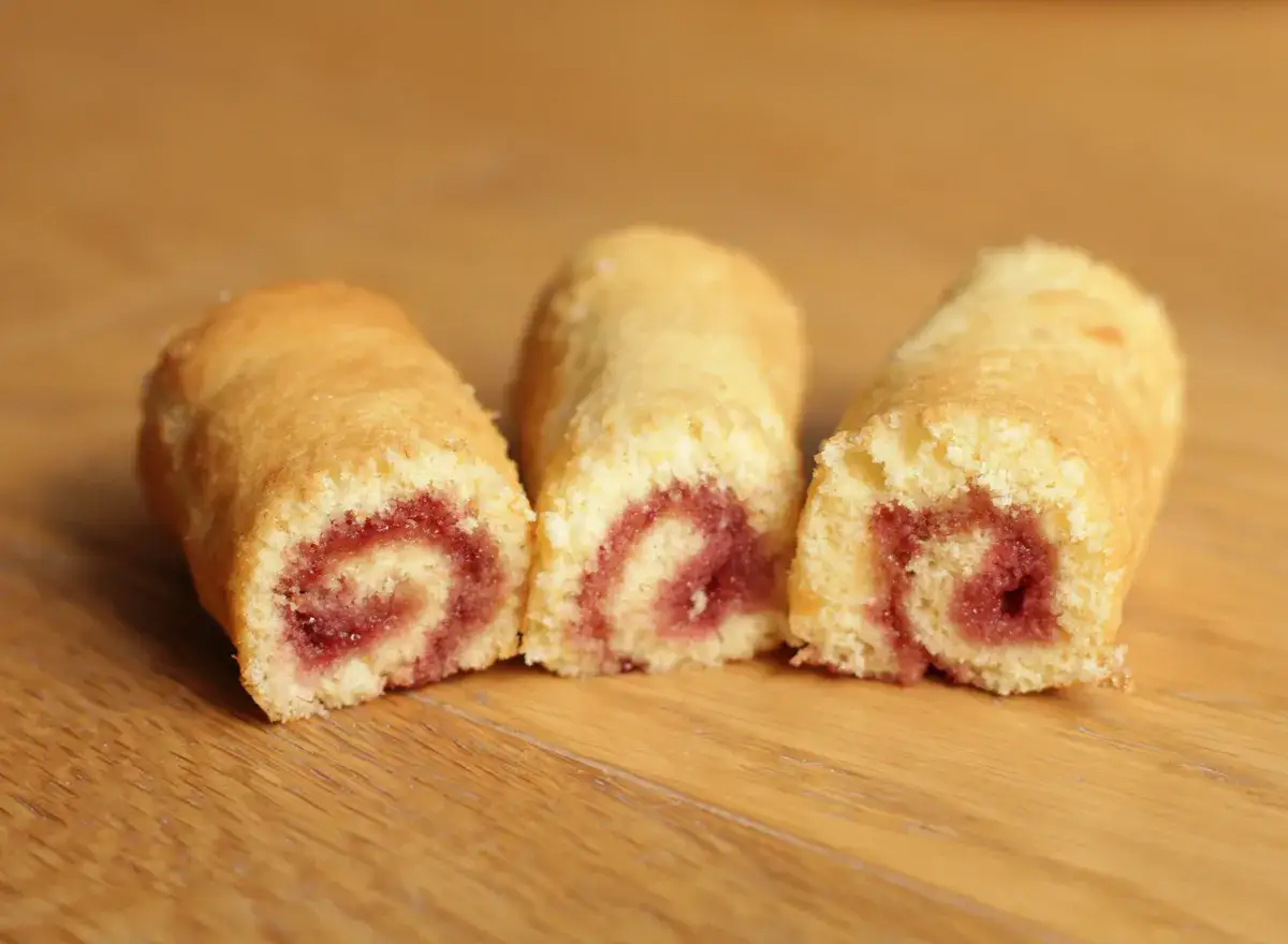Trois petits roulés à la confiture, un délice simple et gourmand, sur fond de bois.