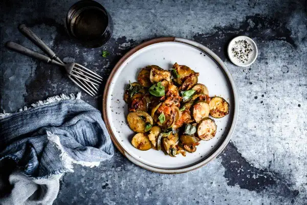 Assiette de courgettes sautées, tomates et basilic frais, parfaite pour une recette basilic simple et savoureuse.