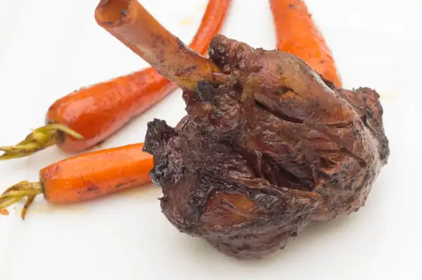 Roussette au vin blanc, une recette de cuisine actuelle, servie avec des carottes glacées sur une assiette blanche.