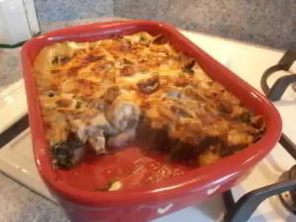 Un gratin des Chartreux tout juste sorti du four, fumant et doré, dans un plat rouge.