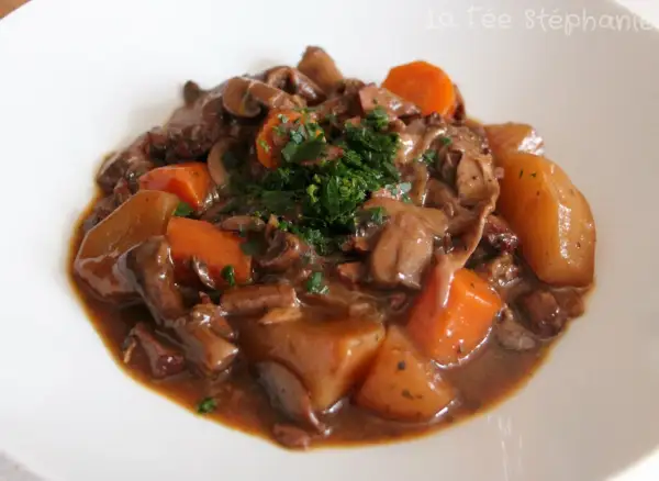 Un savoureux bourguignon végétarien avec des champignons, des carottes et des pommes de terre, garni de persil frais.