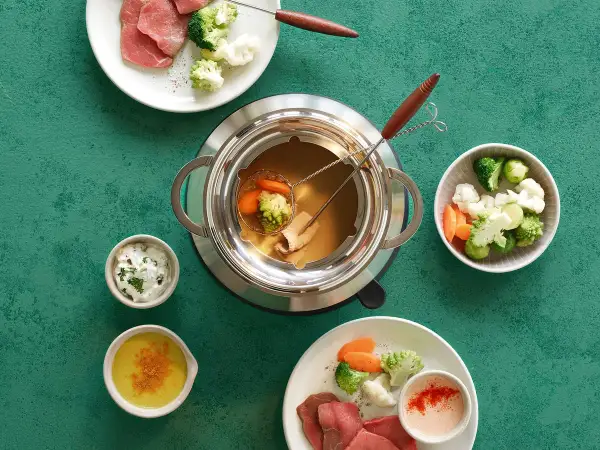 Fondue au bouillon cube avec viande, brocolis, chou-fleur et carottes. Des sauces accompagnent ce plat convivial.