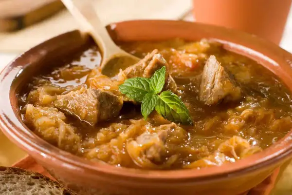 Un plat de goulash polonais réconfortant, avec des morceaux de viande tendre et du chou, garni de menthe fraîche. Parfait pour une recette maison.