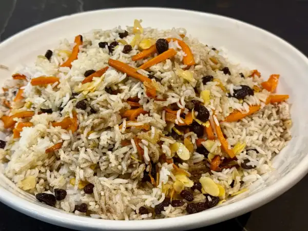 Un plat de riz parfumé, garni de carottes râpées, de raisins secs et d'amandes effilées. Une belle présentation de la recette riz afghan.