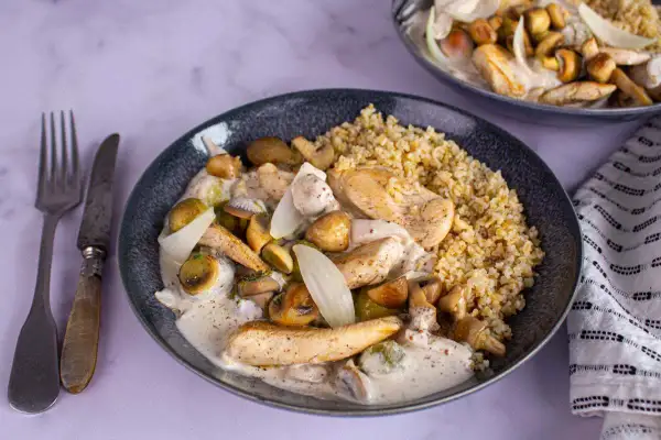 Délicieuse recette au poulet, champignons et oignons dans une sauce crémeuse, servie avec du boulgour. Un plat réconfortant.