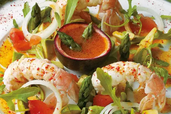 Salade de langouste aux agrumes et avocat, avec asperges et fruits de la passion. Un plat frais et coloré.