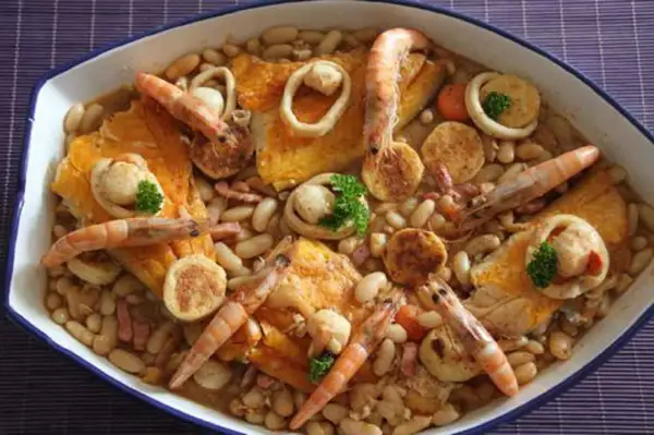 Un cassoulet de la mer facile, un plat généreux avec des crevettes, des calamars et des poissons sur un lit de haricots blancs.