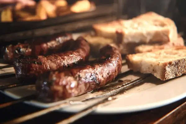 Figatelli grillés au four, accompagnés de tranches de pain rustique. Une recette simple et savoureuse.