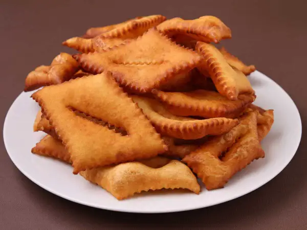 Une assiette de bugnes au four dorées et croustillantes, prêtes à être dégustées.