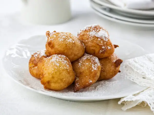 Délicieuses beignets saupoudrés de sucre glace, parfaits pour une recette crotte d'âne maison.