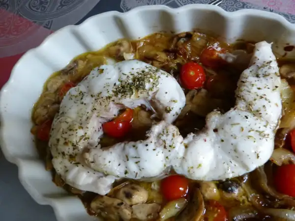 Filet de congre au four, tendre et savoureux, servi avec des tomates cerises et des champignons dans un plat blanc.