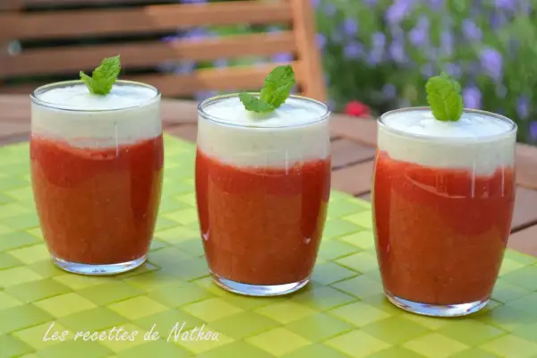 Trois verres de soupe fraise menthe, garnie d'une feuille de menthe, sur une table verte.